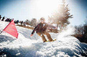 image of a snowboarder shreding past a red flag